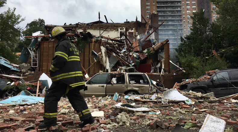 A New York City firefighter walks over debris left behind by a home explosion in the Bronx on Tuesday, Sept. 27, 2016.