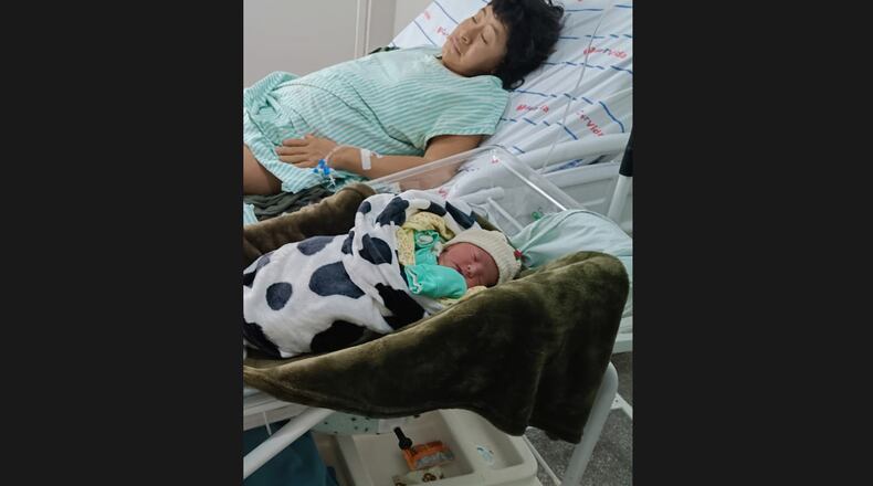 In this photo provided by Funai, Babawru Akuntsu, top, rests beside Akyp, her newborn son, at the Regional Hospital of Vilhena in Vilhena, Rondonia state, Brazil on Dec. 9, 2025, one day after the birth. (Altair Algayer/Funai via AP)