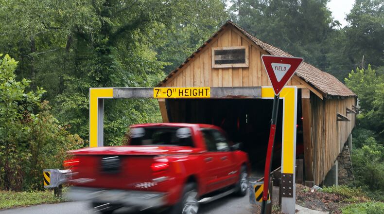 The Concord Covered Bridge over Nickajack Creek has a low clearance and gets hit multiple times per year, usually by rented trucks that don’t clear the warning beam. BOB ANDRES / BANDRES@AJC.COM