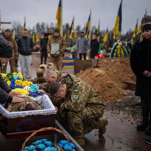 Natalia cries at the coffin of her son Ruslan Zhygunov, a Ukrainian serviceman, who was killed at the frontline near Rusyn Yar village, during his funeral ceremony in Hostomel, Ukraine, on Saturday, Nov. 22, 2025. (AP Photo/Evgeniy Maloletka)