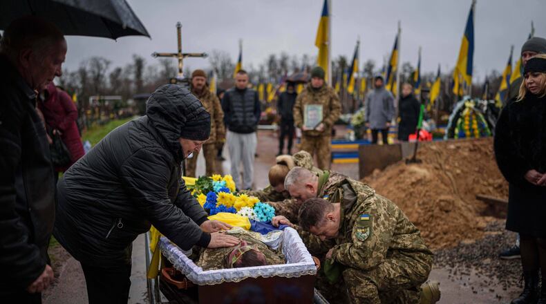 Natalia cries at the coffin of her son Ruslan Zhygunov, a Ukrainian serviceman, who was killed at the frontline near Rusyn Yar village, during his funeral ceremony in Hostomel, Ukraine, on Saturday, Nov. 22, 2025. (AP Photo/Evgeniy Maloletka)