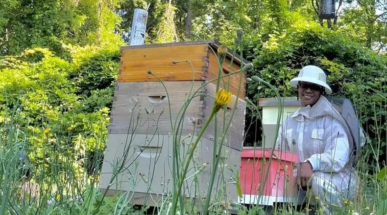 Simone Fyffe is seen here caring for her bee colony. Her business, Art + Honey Co. by PCS LLC, incorporates her two passions, art and bees. (Sydney Sims/Capital B)