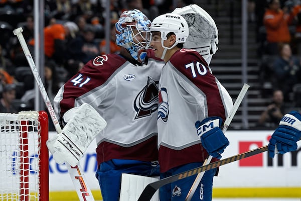 Colorado Avalanche defenseman Sam Malinski (70) celebrates with goaltender Scott Wedgewood (41) after the Avalanche defeated the Anaheim Ducks in an NHL hockey game in Anaheim, Calif., Sunday, April 13, 2025. (AP Photo/Alex Gallardo)