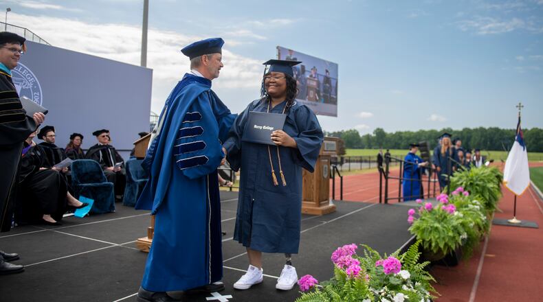 Berry College President Steve Briggs (left) congratulates Anaiah Rucker during the 2023 commencement ceremony. Rucker was 10 when she saved her sister from an oncoming truck, suffering serious injuries, including losing a leg. Rucker received national attention after ABC's "Extreme Makeover: Home Edition" documented her story. After hearing Rucker's story, Berry College offered her a full scholarship. (Courtesy of Brant Sanderlin/Berry College)