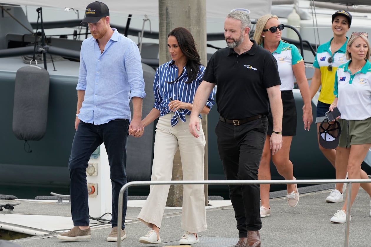 FILE - Prince Harry, left, and his wife Meghan, the Duke and Duchess of Sussex, arrive at a dock after sailing on the harbor in Sydney, Friday, April 17, 2026. (AP Photo/Rick Rycroft, File)