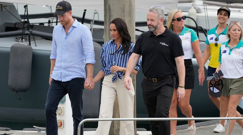FILE - Prince Harry, left, and his wife Meghan, the Duke and Duchess of Sussex, arrive at a dock after sailing on the harbor in Sydney, Friday, April 17, 2026. (AP Photo/Rick Rycroft, File)