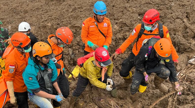 In this photo released by the Indonesian National Search and Rescue Agency (BASARNAS), rescuers search for victims in Pasir Langu village after a landslide, in West Bandung district of West Java province, Indonesia, Sunday, Jan. 25, 2026. (BASARNAS via AP)