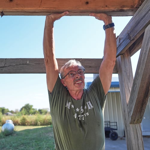 Ed Westrick, 59, adjusts a roof on a small building at his rural home near Commerce, Texas, Friday, Sept. 18, 2026. (AP Photo/LM Otero)