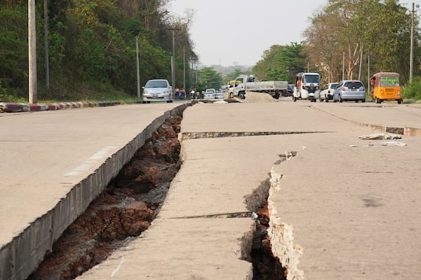 Vehicles make their way near a road damaged by an earthquake Friday, March 28, 2025, in Naypyitaw, Myanmar. (AP Photo/Aung Shine Oo)