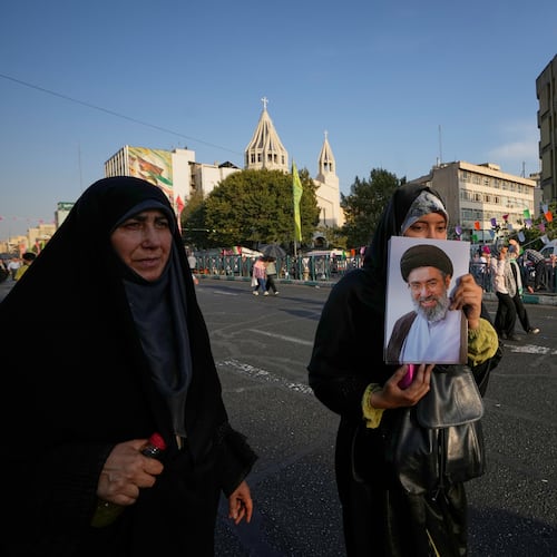 A government supporter holds a portrait of Iran's Supreme Leader Mojtaba Khamenei during a street celebration marking Prophet Muhammad's birthday, with St. Sarkis Armenian Cathedral in the background, in Tehran, Iran, Sunday, Aug. 30, 2026. (AP Photo/Vahid Salemi)