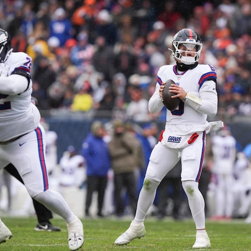 New York Giants quarterback Jaxson Dart, center, looks to throw during the first half of an NFL football game against the Chicago Bears, Sunday, Nov. 9, 2025, in Chicago. (AP Photo/Nam Y. Huh)