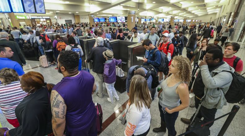 Long lines for airport security screening stretched through the domestic terminal and snaked through baggage claim at Hartsfield-Jackson International on Monday, May, 9, 2016. The airport is now advising travelers to get to the terminal three hours before their flight. JOHN SPINK / JSPINK@AJC.COM