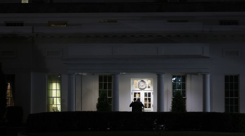 People are seen outside the West Wing driveway entrance of the White House, Saturday, April 25, 2026, in Washington. (AP Photo/Tom Brenner)