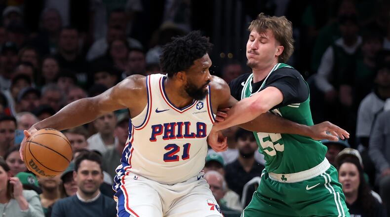 Boston Celtics' Jayson Baylor Scheierman (right) defends agianst Philadelphia 76ers' Joel Embiid (left) during the first half of Game 7 in a first-round NBA basketball playoffs series, Saturday, May 2, 2026 in Boston. (AP Photo/Jim Davis)
