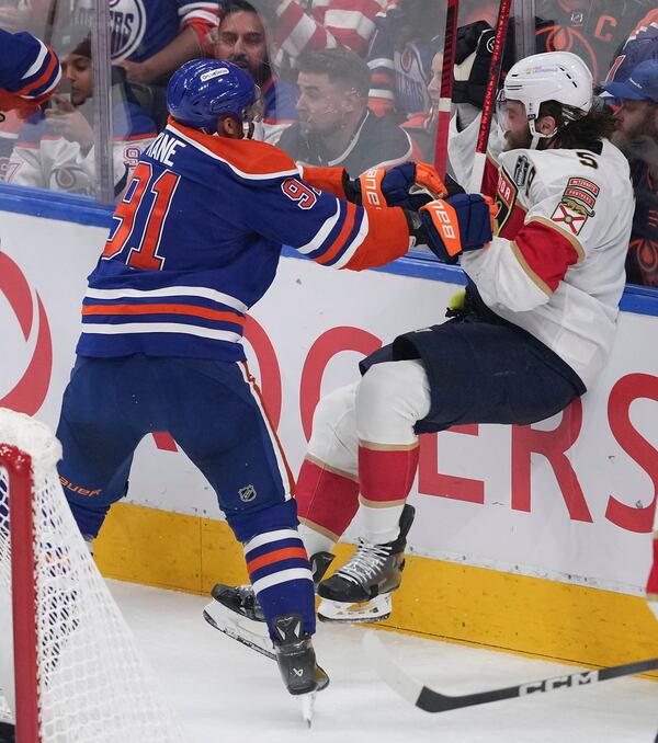 Edmonton Oilers' Evander Kane (91) checks Florida Panthers' Aaron Ekblad (5) during the first period in Game 1 of the NHL Stanley Cup Final, in Edmonton, Alberta, on Wednesday, June 4, 2025. (Darryl Dyck/The Canadian Press via AP)