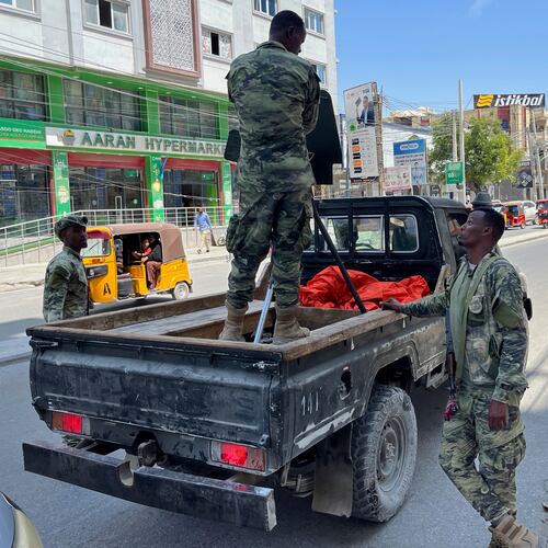 A Somali National Army (SNA) soldier stands in the back of a pickup truck as others stand nearby on a street in Mogadishu, Somalia, Monday, Nov. 10, 2025. (AP Photo/Rodney Muhumuza)