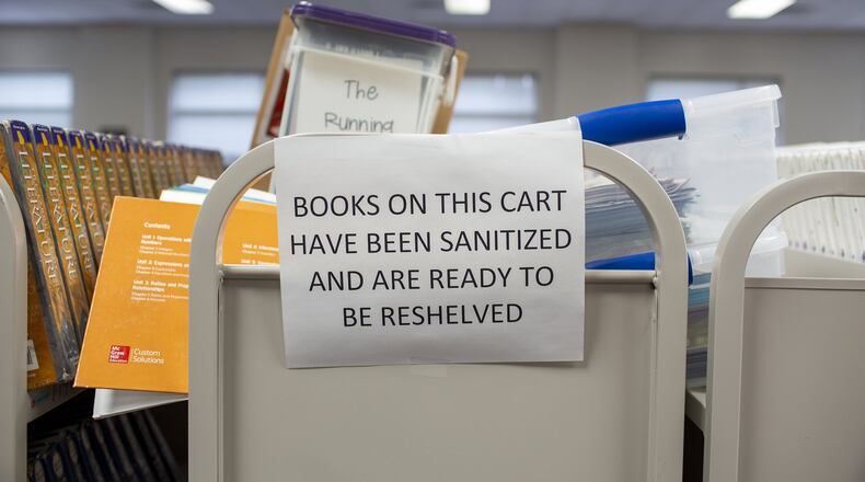 Sanitized books wait to be reshelved in Northbrook Middle School in Suwanee, Georgia, earlier this month. Gwinnett County Public Schools, the state’s largest system, had planned to reopen its buildings to students on Aug. 12 but now is going fully digital to start off. REBECCA WRIGHT FOR THE ATLANTA JOURNAL-CONSTITUTION