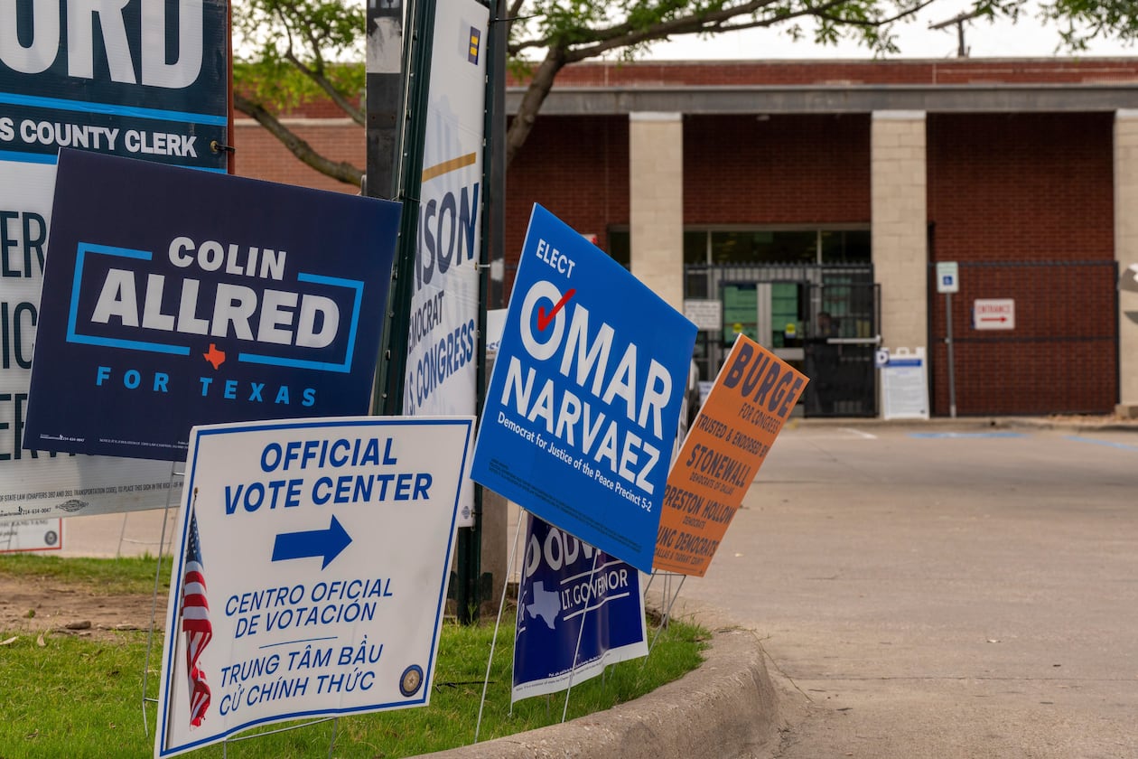 Candidate signs line the entrance to the Oak Lawn Branch Library polling location as voters cast ballots in local and primary runoff elections Tuesday, May 26, 2026, in Dallas. (AP Photo/Gabriela Passos)