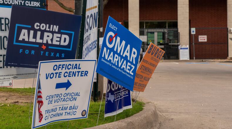 Candidate signs line the entrance to the Oak Lawn Branch Library polling location as voters cast ballots in local and primary runoff elections Tuesday, May 26, 2026, in Dallas. (AP Photo/Gabriela Passos)