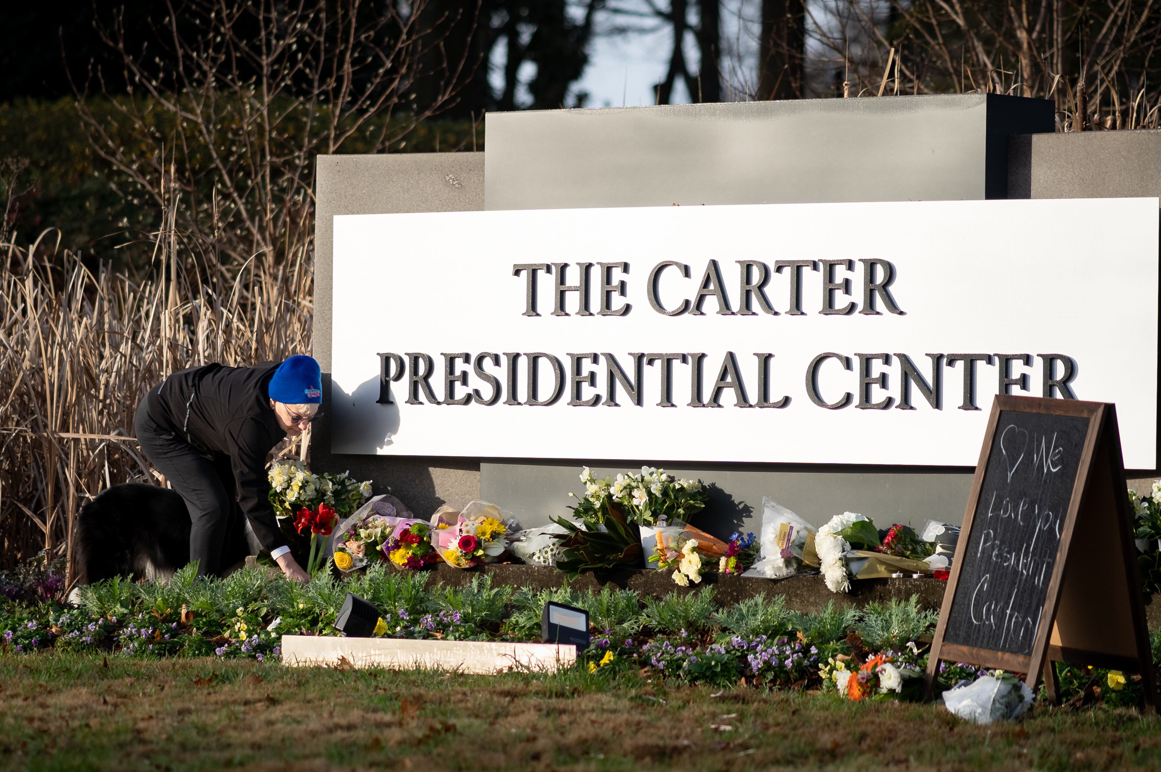 Flowers, candles and peanuts line the sign at The Carter Presidential Center in Atlanta,Georgia after the death of the former president.