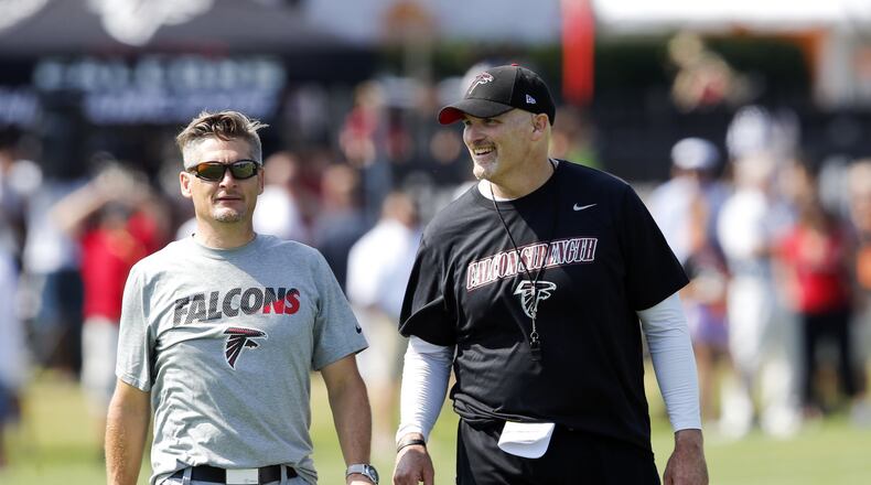 Atlanta Falcons head coach Dan Quinn, right, talks with general manager Thomas Dimitroff during an NFL football training camp in Flowery Branch, Ga.