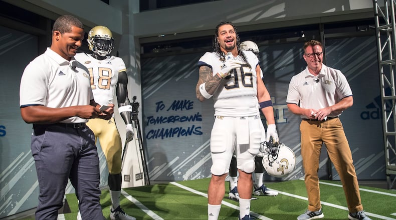 Professional wrestler and former Georgia Tech football player Roman Reigns (center) models the new football uniforms during a reveal party in Atlanta, Friday, August 3, 2018. (ALYSSA POINTER/ALYSSA.POINTER@AJC.COM)