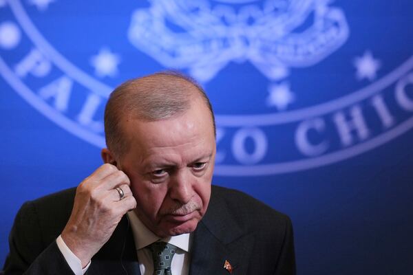 Turkish President Recep Tayyip Erdogan adjusts his earphones during a joint press conference with Italian Premier Giorgia Meloni, at Villa Pamphilj in Rome, Tuesday, April 29, 2025. (AP Photo/Francisco Seco)