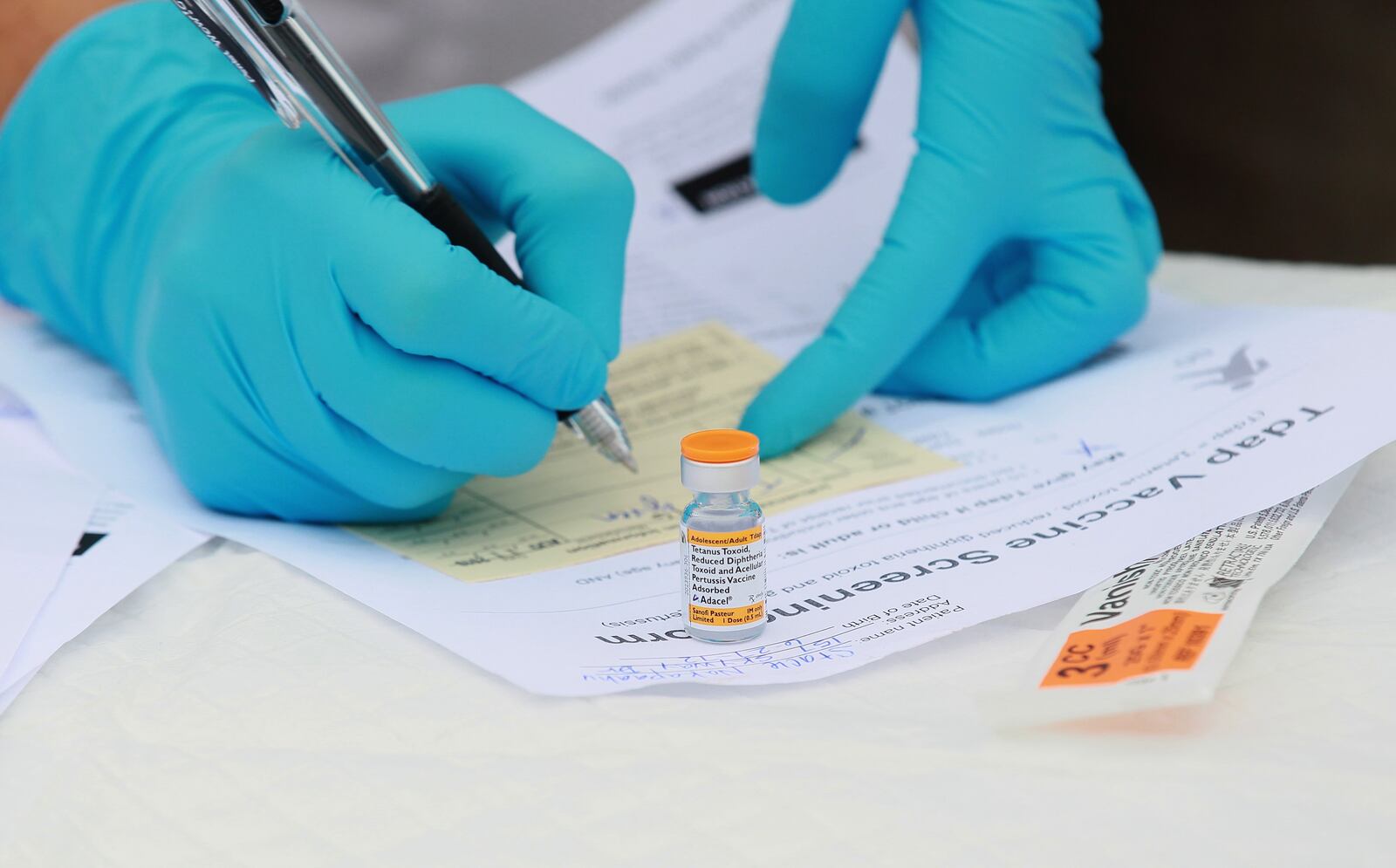 VALLEJO, CA - AUGUST 11: Touro University medical student Shamis Fallah prepares paperwork before adminstering a Tdap vaccination during the Solano County health fair August 11, 2010 in Vallejo, California. California medical officials are urging California residents to get booster shots for whooping cough as the state is in the midst of the largest outbreak in over fifty years. Close to 1,500 cases of whooping cough have been reported this year, including six cases that resulted in deaths of children under three years old. Photo by Justin Sullivan/Getty Images