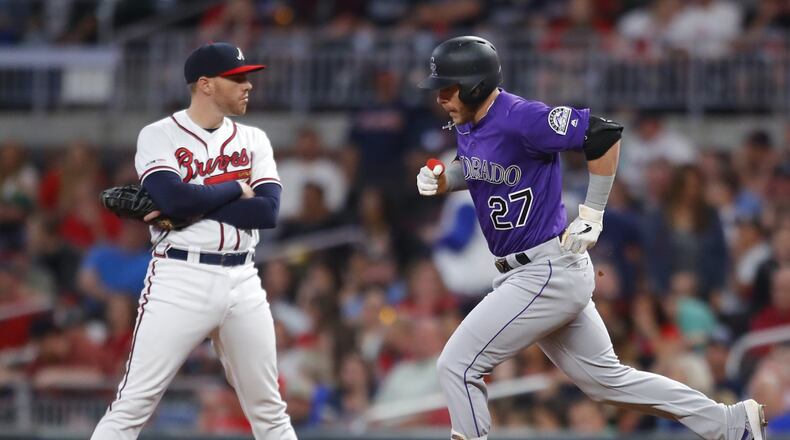 Trevor Story of the Colorado Rockies rounds first after hitting a three run home run as Freddie Freeman #5 of the Atlanta Braves reacts in the ninth inning. (Photo by Todd Kirkland/Getty Images)