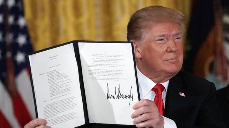 President Donald Trump holds up an executive order that he signed during a meeting of the National Space Council at the East Room of the White House June 18, 2018 in Washington, DC. President Trump signed an executive order to establish the Space Force, an independent and co-equal military branch, as the sixth branch of the U.S. armed forces.