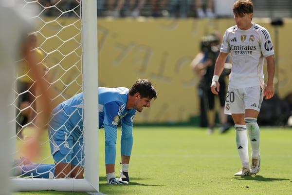 Real Madrid's Thibaut Courtois kneels on the ground besides team mate Fran Garcia during the Club World Cup semifinal soccer match between PSG and Real Madrid in East Rutherford, N.J., Wednesday, July 9, 2025. (AP Photo/Adam Hunger)
