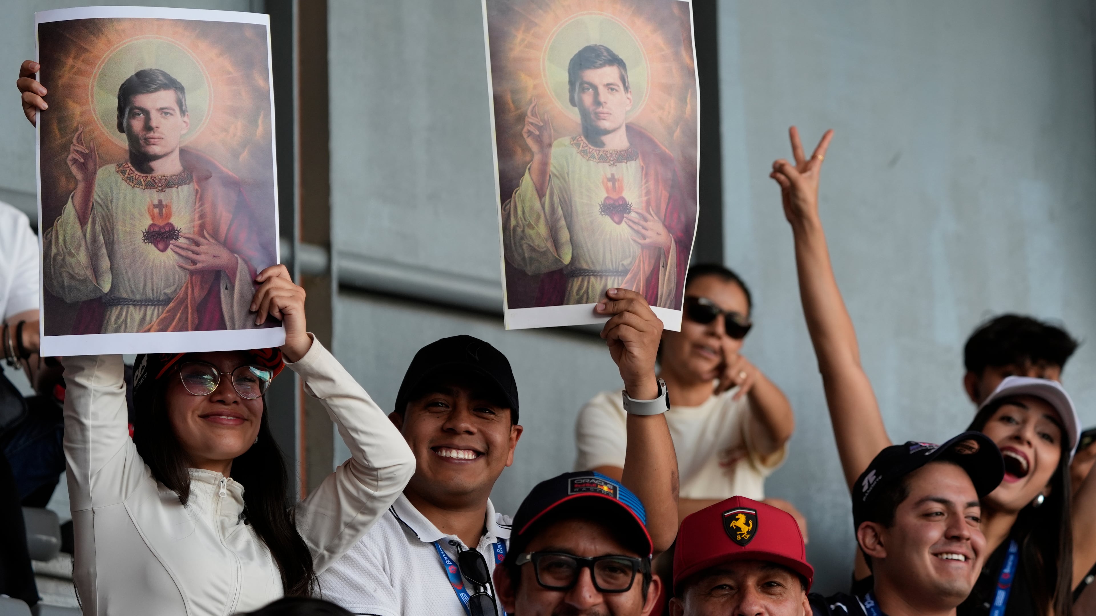 Fans of Max Verstappen of the Netherlands hold posters depicting him as the Scared of Jesus during a practice session of the Formula One Mexico Grand Prix auto race at the Hermanos Rodriguez race track in Mexico City, Friday, Oct. 24, 2025. (AP Photo/Fernando Llano)