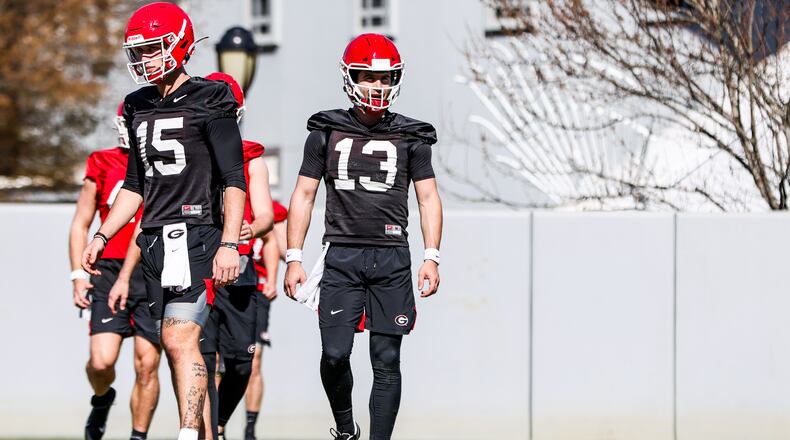 Georgia quarterback Stetson Bennett (13) looks to the sideline for a signal while fellow quarterback Carson Beck (15) does the same during a 'two-spotting' passing session during one of Georgia’s recent spring practices in Athens (Photo by Tony Walsh/UGA Athletics)