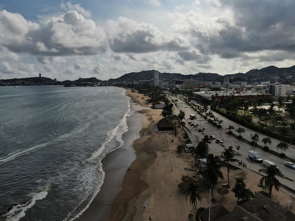 Tourists stroll along the beach shore before the arrival of Hurricane Erick, in Acapulco, Mexico, Wednesday, June 18, 2025. (AP Photo/Fernando Llano)