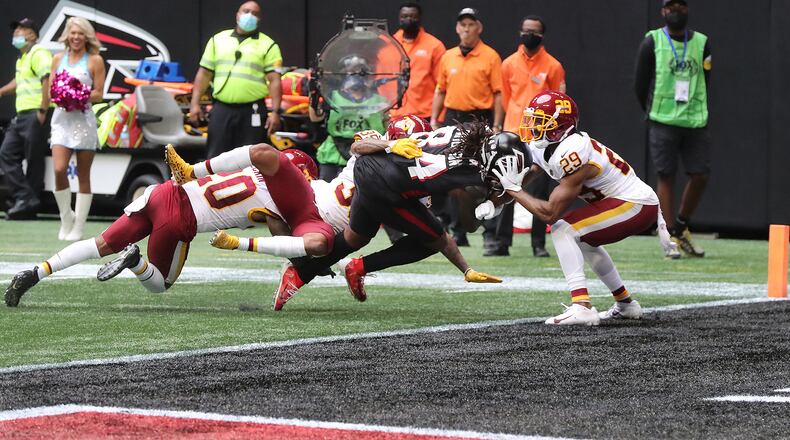 Falcons running back Cordarrelle Patterson bears down to reach the end zone against three defenders to take a 17-13 lead over the Washington Football Team during the final minute of the second quarter Sunday, Oct. 3, 2021, at Mercedes-Benz Stadium in Atlanta.   (Curtis Compton / Curtis.Compton@ajc.com)