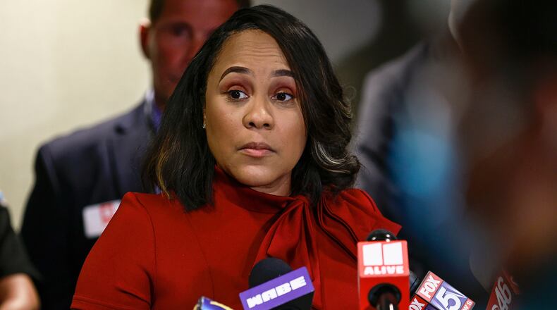 Surrounded by Fulton County law enforcement officials, District Attorney Fani Willis speaks during a news conference about the RICO indictment in the celebrity home invasion ring on Aug. 29, 2022. (Natrice Miller/Atlanta Journal-Constitution/TNS)