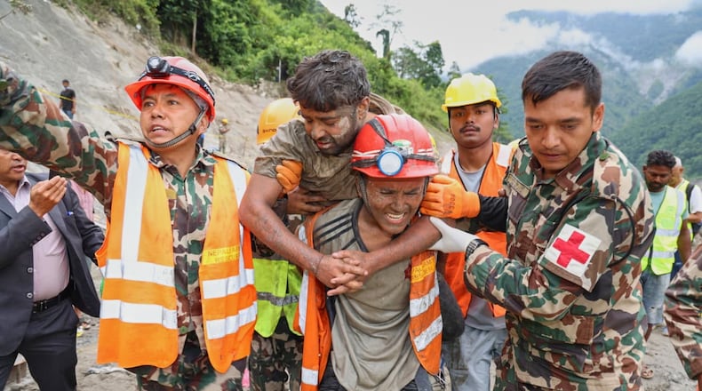 In this photo provided by the Nepal Army, soldiers rescue a worker alive from a tunnel during an ongoing operation at the Trishuli-3A hydropower project in Nepal's Rasuwa district, Friday, Sept. 4, 2026. (Nepal Army via AP)