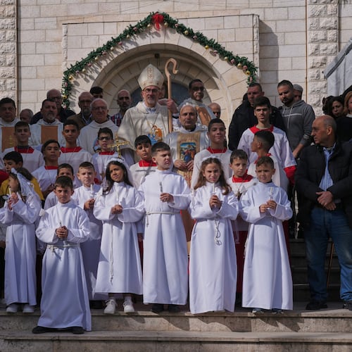 Cardinal Pierbattista Pizzaballa, the Latin Patriarch of Jerusalem, poses for the photos with Palestinian parishioners after leading a mass ahead of Christmas celebrations at the Holy Family Catholic Church in Gaza City, Sunday, Dec. 21, 2025. (AP Photo/Jehad Alshrafi)