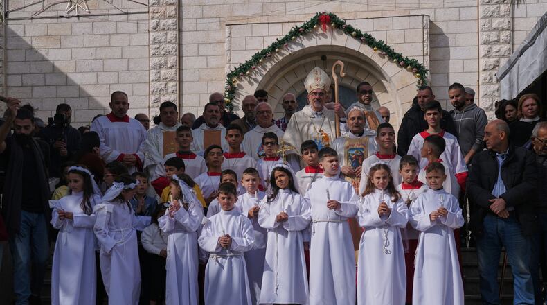 Cardinal Pierbattista Pizzaballa, the Latin Patriarch of Jerusalem, poses for the photos with Palestinian parishioners after leading a mass ahead of Christmas celebrations at the Holy Family Catholic Church in Gaza City, Sunday, Dec. 21, 2025. (AP Photo/Jehad Alshrafi)