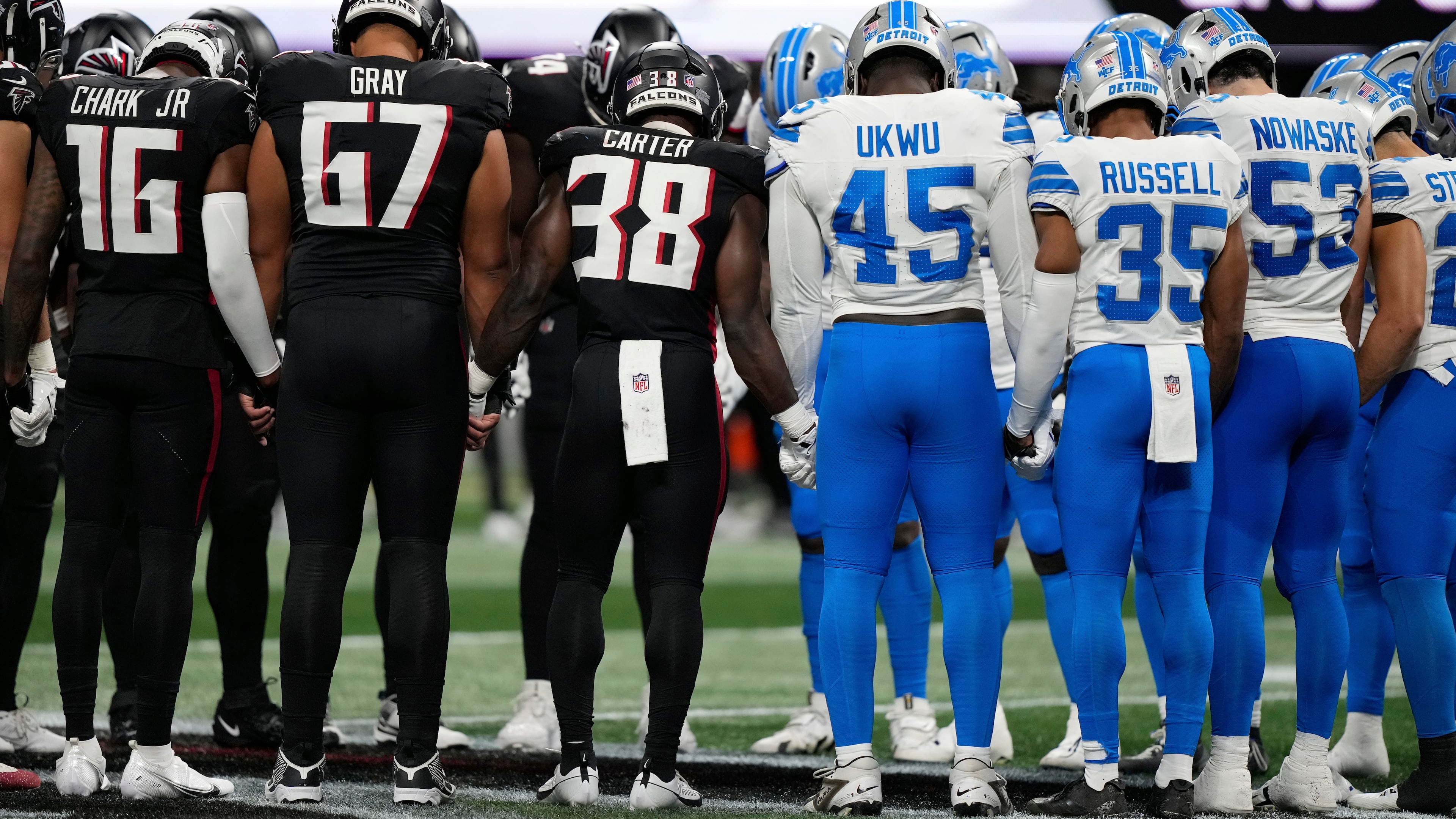 Atlanta Falcons and Detroit Lions players stand on the field hand in hand together after Detroit Lions safety Morice Norris was injured during the second half of an NFL preseason football game Friday, Aug. 8, 2025, in Atlanta. (AP Photo/Brynn Anderson)