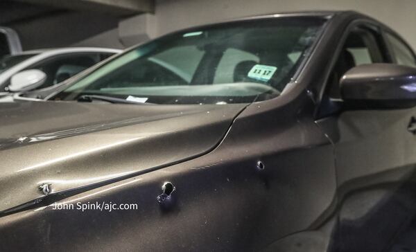 Multiple bullet holes could be seen in the side of a gray sedan parked in the deck at the Mark at West Midtown on Bishop Street.