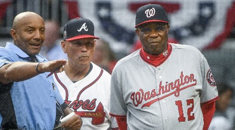 Umpire C.B. Bucknor talking with managers Brian Snitker and Dusty Baker before Tuesday’s game—and before he blew a call at the end. (AP Photo)