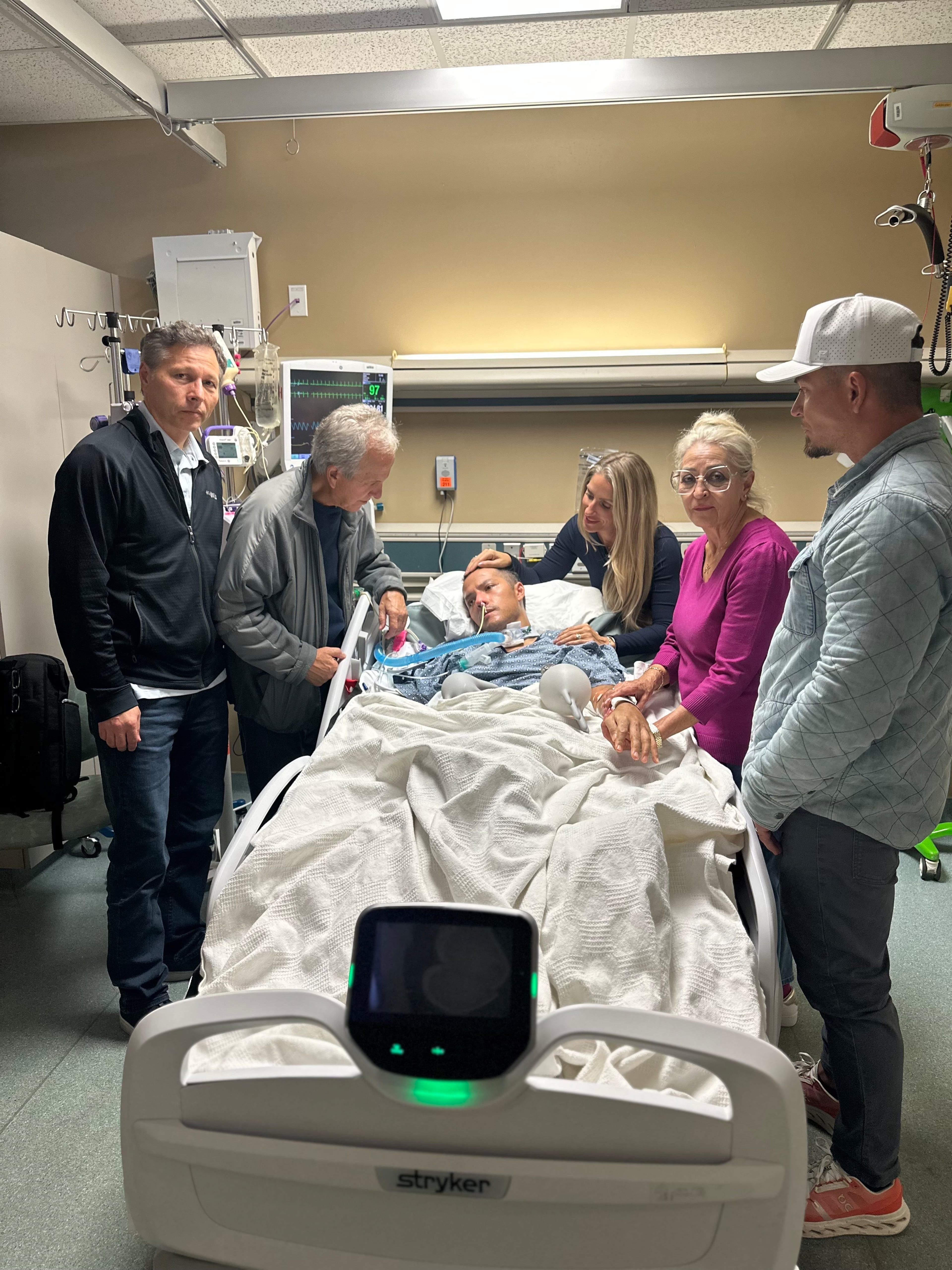 Mark Moczarski is surrounded by his parents and siblings after he was flown back to metro Atlanta following a moped crash in Bali last month. (Courtesy Moczarski family)