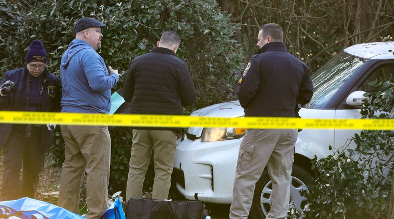 Investigators worked to learn who shot a man who crashed his SUV in the front yard of a Gwinnett County home Jan. 27. (John Spink / John.Spink@ajc.com)
