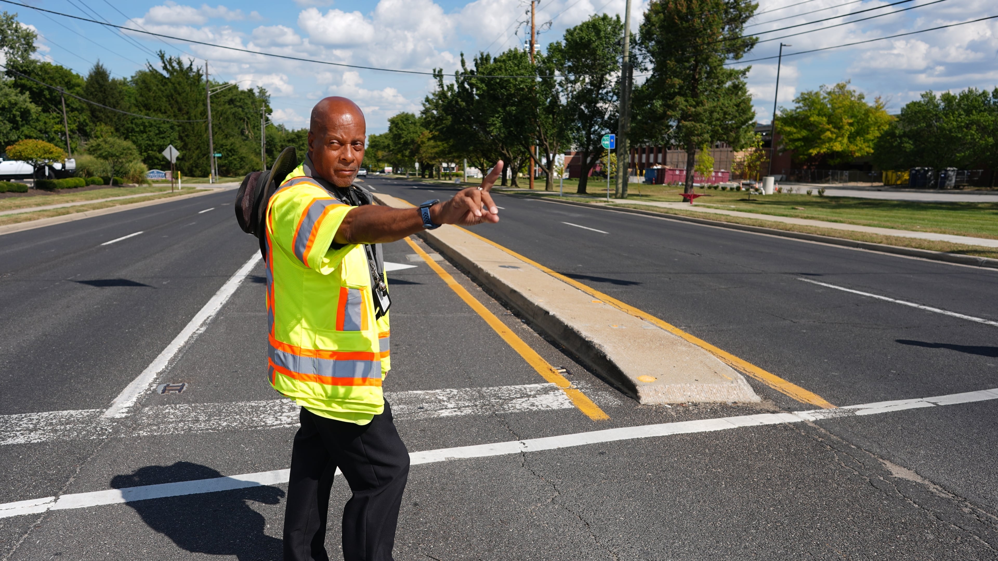 School crossing guard Anthony Taylor directs students on when to cross the street, Wednesday, Sept. 3, 2025, in Indianapolis. (AP Photo/Darron Cummings)