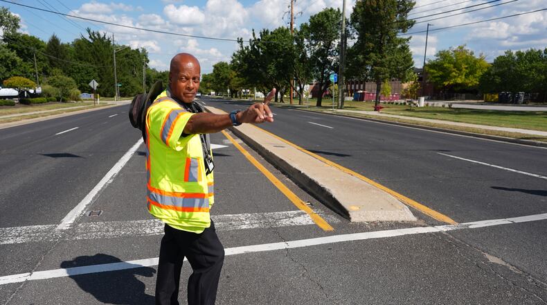 School crossing guard Anthony Taylor directs students on when to cross the street, Wednesday, Sept. 3, 2025, in Indianapolis. (AP Photo/Darron Cummings)