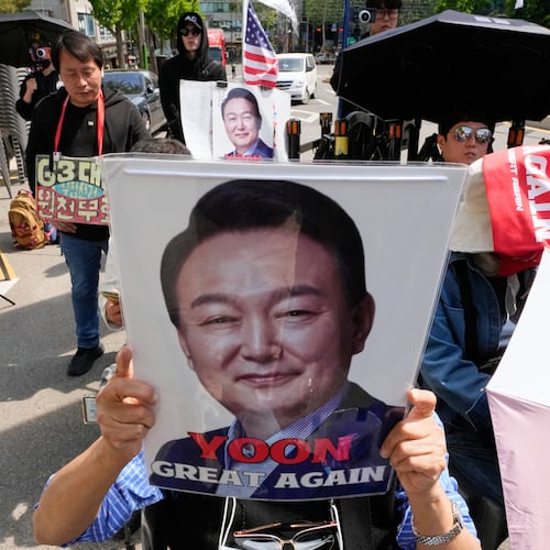 A supporter of former South Korean President Yoon Suk Yeol holds up his portrait during a rally outside of the Seoul High Court in Seoul, South Korea, Wednesday, April 29, 2026. (AP Photo/Ahn Young-joon)