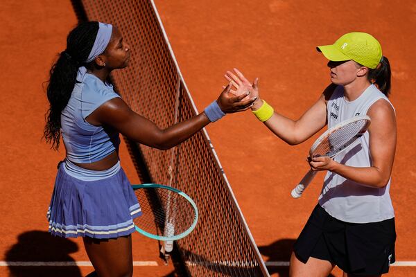 United States' Coco Gauff, left, shakes hands with Iga Swiatek of Poland at the end of the match during the Madrid Open tennis tournament in Madrid, Spain, Thursday, May 1, 2025. (AP Photo/Manu Fernandez)