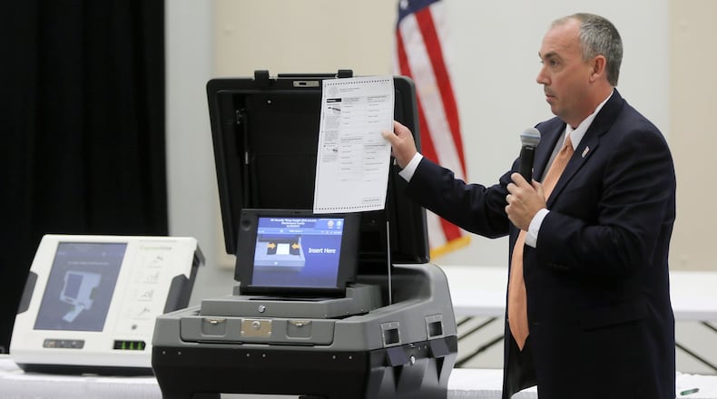 Mac Beeson from Election Systems & Software demonstrates the scanner portion of his company’s voting system during a meeting Thursday of the state’s Secure, Accessible & Fair Elections Commission, which is which is evaluating whether to switch from electronic voting machines to ones that offer paper ballots for verification and auditing. Voting machine companies demonstrated their products at the Columbia County Exhibition Center. Vendors present included Clear Ballot, Unisyn Voting Solutions, Smartmatic, Election Systems & Software, Hart InterCivic and Dominion Voting. BOB ANDRES /BANDRES@AJC.COM