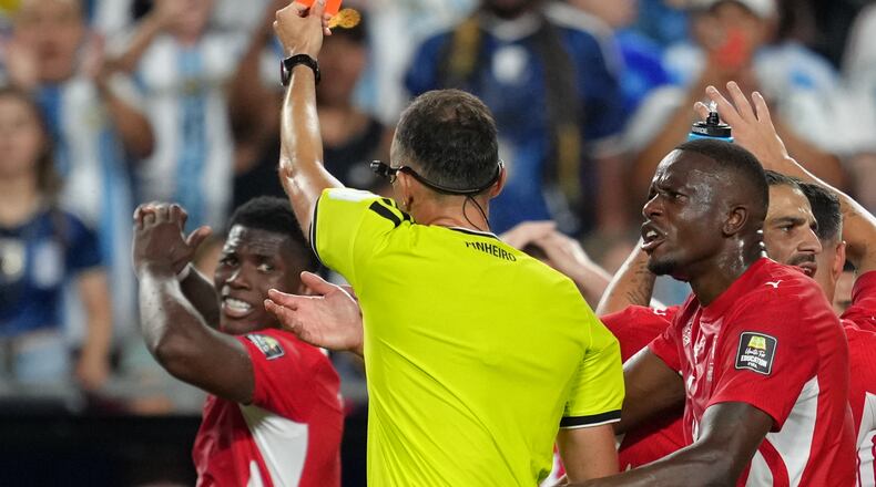 Referee Joao Pinheiro, of Portugal, gives a red card to Switzerland's Breel Embolo (7), left, during the World Cup quarterfinal soccer match between Argentina and Switzerland in Kansas City, Mo., Saturday, July 11, 2026. (AP Photo/Ed Zurga)